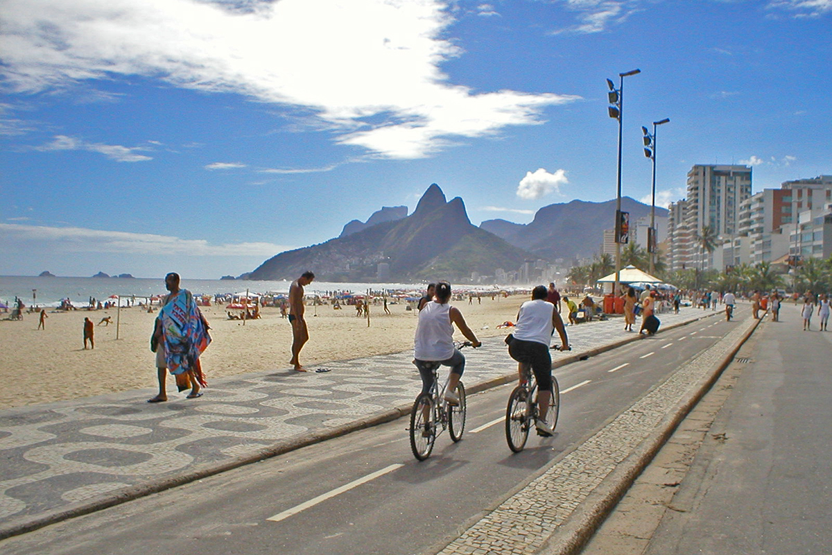 riogayguide Gay Magazine | Riding on the bicycle lane along Ipanema Beach.
